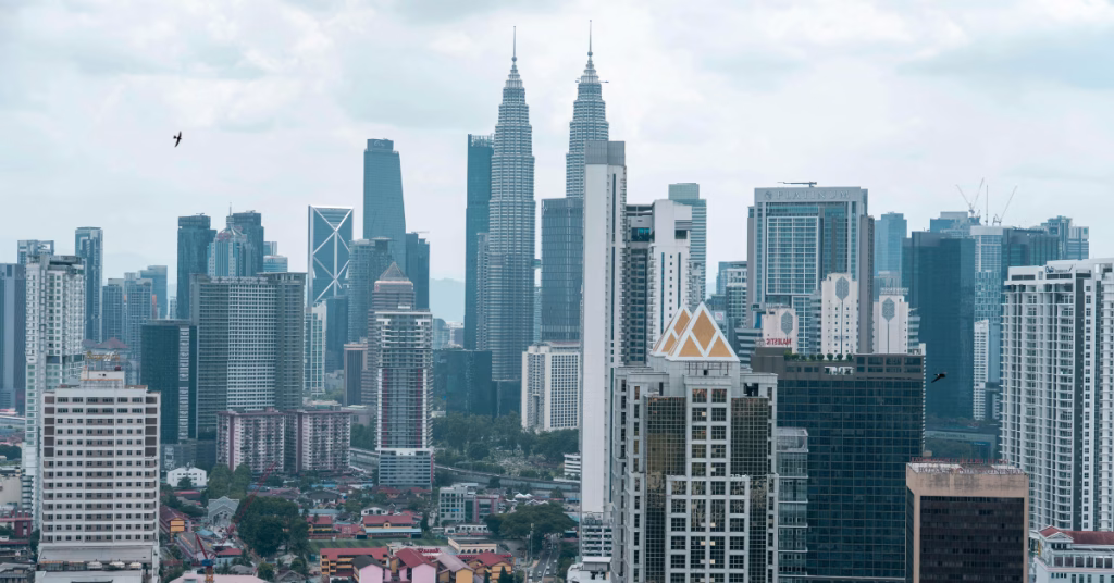 a city skyline of Kuala Lumpur at day time showing the petronas twin towers