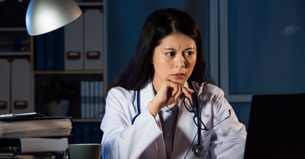 a female asian doctor looking at a laptop having a problem